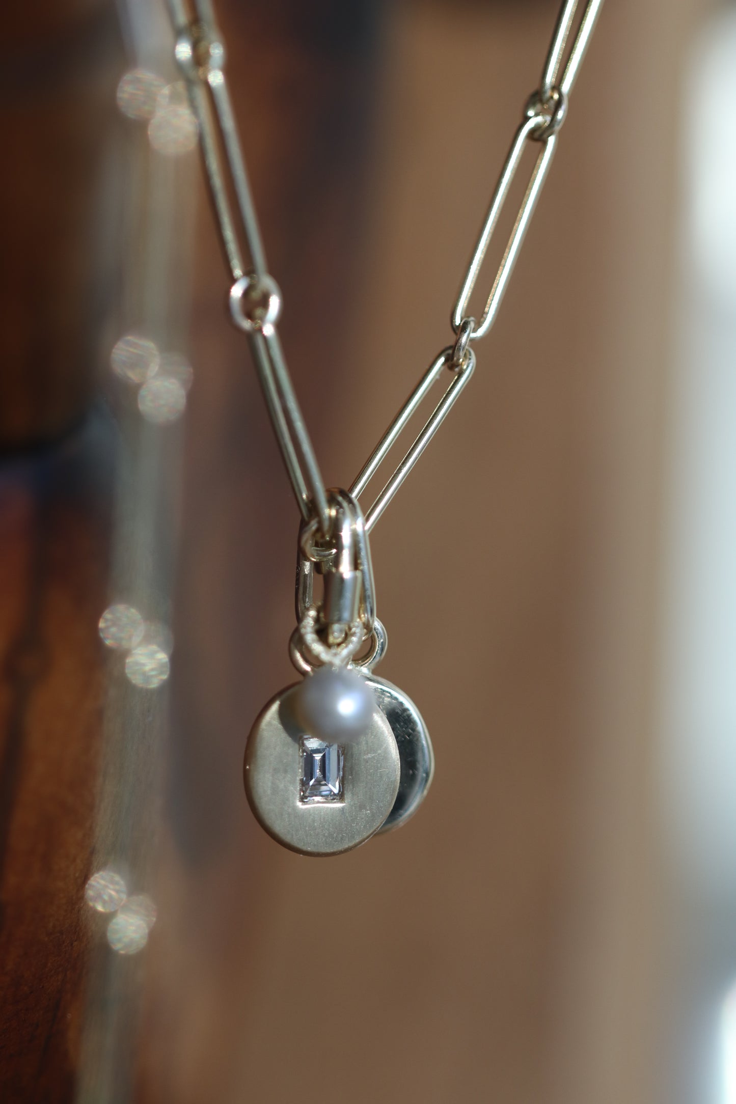 Gold pebble disc charm with baguette sapphire & diamonds
