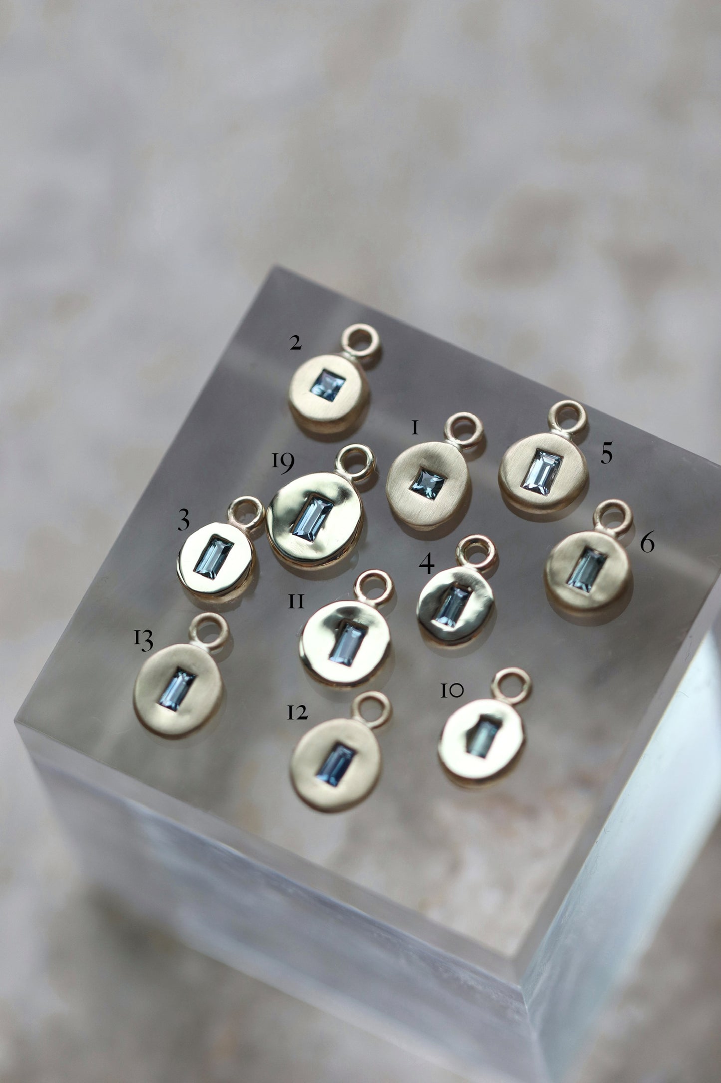 Gold pebble disc charm with baguette sapphire & diamonds