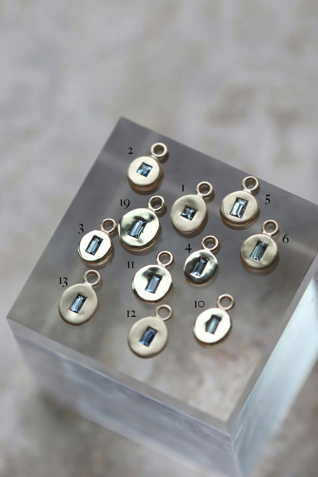 Gold pebble disc charm with baguette sapphire & diamonds